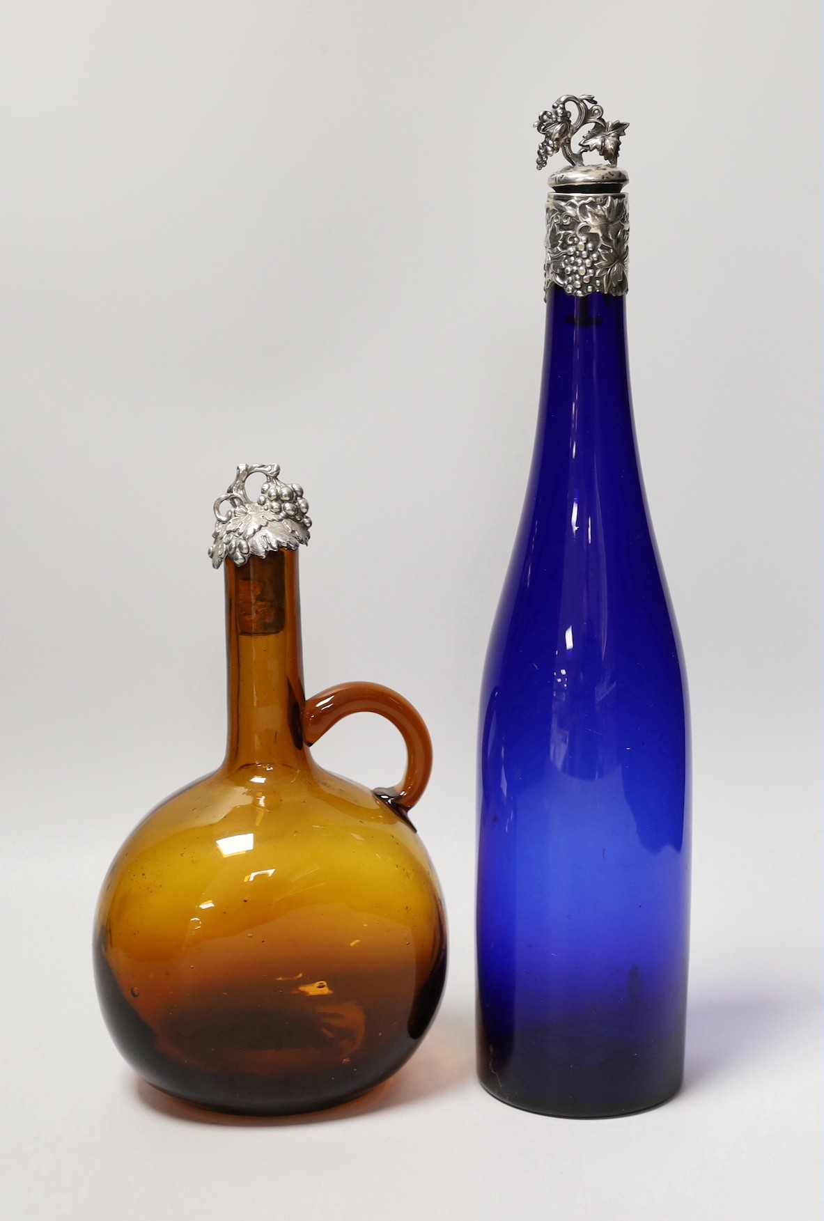 A blue glass hock bottle with George IV silver stopper and an amber glass spirit flask with William IV silver stopper. Tallest 35cm